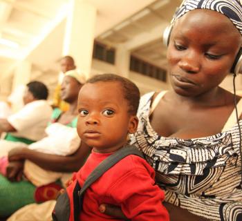 A woman with her baby on her lap watches a video on a computer pre-loaded with practical information about what to expect during childbirth. A woman with her baby on her lap watches a video on a computer pre-loaded with practical information about what to expect during childbirth.