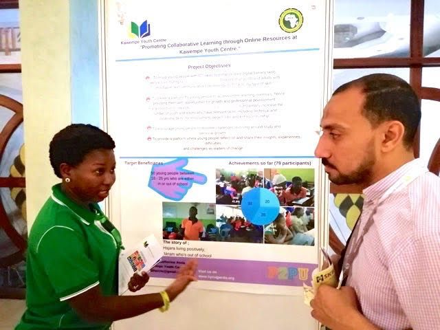Poster session at the AfLIA conference: IYALI participant Mustafa Tuhami from Egypt (right) in deep discussion Catherine Amia of Kawempe Youth Centre, Uganda. Mustafa was especially interested in Kawempe Youth Centre’s educational service for young people, featured in the poster.
