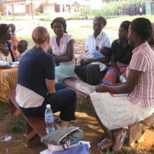 A health workers discussing health issues with a group of women.