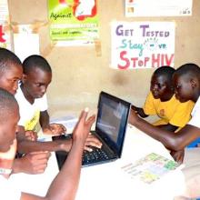 Teenagers using laptops to research the internet for health information in their library.