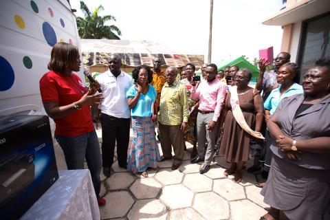 At the launch celebration in Western Region, Edith Boadu, project coordinator, demonstrates the equipment that the newly-equipped mobile library vans will take to schools. Photo by Ryan Yingling