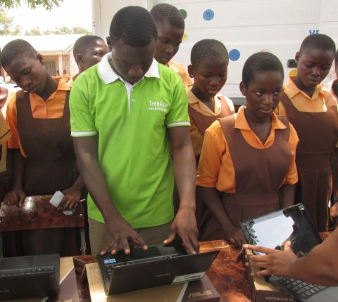 Children watch as technicians configure Volta Regional Library’s new laptops, bought with support from people who donated through the GlobalGiving fundraising website.