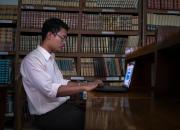 Young man studying at the computer in Myanmar library.