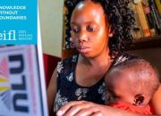 Image of the cover of the 2023 EIFL Annual Report, showing an Ugandan mother learning to use a computer, with a child on her lap. 