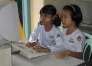 Burmese girls working at a computer.