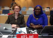 Teresa Hackett sitting next to Awe Cisse in the WIPO meeting hall. 