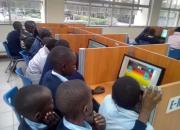 Children crowding around computers in the library.