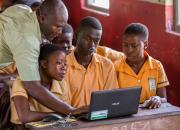 teacher showing children a laptop computer