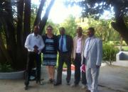 In photo training participants posing in front of the garden