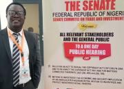 Desmond Oriakhogba, Senior Lecturer, University of the Western Cape, South Africa, with a poster advertising the 2021 Senate hearing on the Copyright Bill in Lagos, Nigeria.