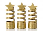 Three innovation award trophies - a golden spiral design, with a star on top.