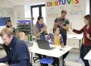 librarians, parents and children with a computer in the maker space