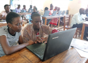 Women and youth in the library, with computers, learning ICT skills.