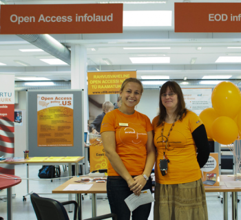 Photo of two Open Access Week organizers and speakers in Estonia standing in front of their booth. 