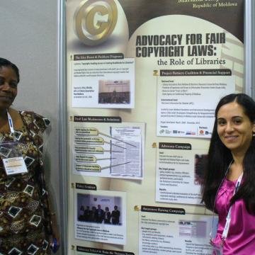 Photo of EIFL copyright librarians from Ghana and Moldova at a poster session at IFLA. The poster is entitled 'Advocacy for access to knowledge, the role of libaries'.
