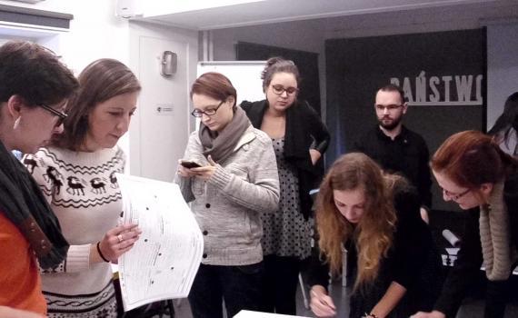 Students reading documents at a workshop in Poland.