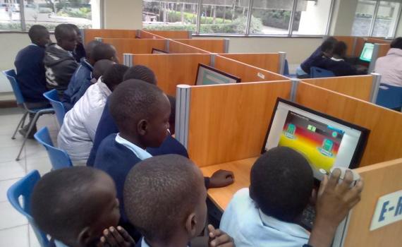 Children crowding around computers in the library.