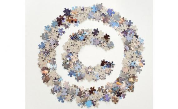 The letter C surrounded by a circle made up of jigsaw pieces.