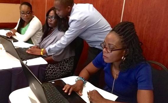 Three librarians at computers, with their facilitator.