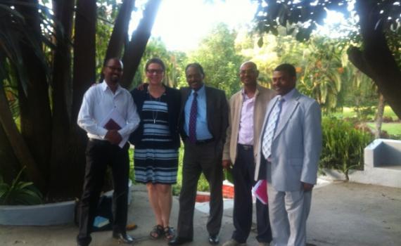 In photo training participants posing in front of the garden