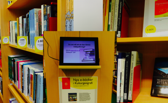Digital photo frame on the library shelf.