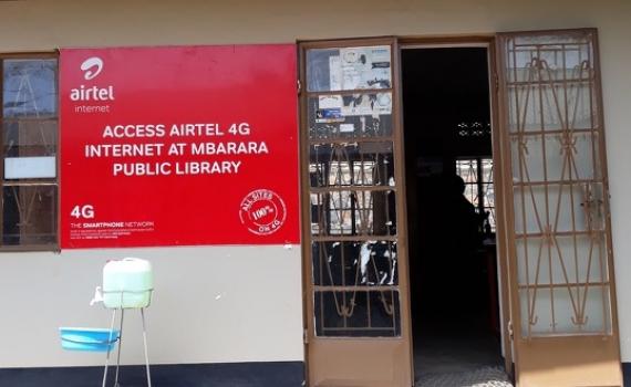 Front of Mbarara Public Library building, showing sign advertising Airtel internet access at the library.