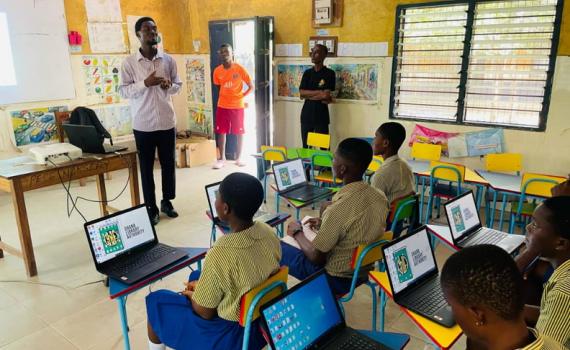 Ghanaian schoolchildren learning to use computers in a school classroom.