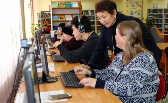 A librarian trains people with disability to use computers in the library.