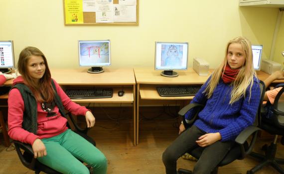Children use the library's computers to create animated films about local history. Two girls with their computers, showing how they make animated films.