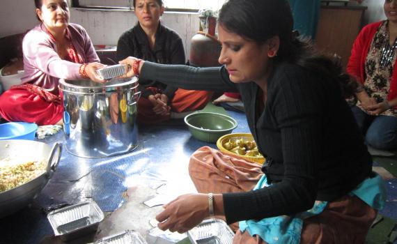 A group of women who learnt business skills at the library fill lunch boxes which the sell, as a small business.