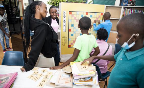 Children playing giant scrabble on a board in the library.