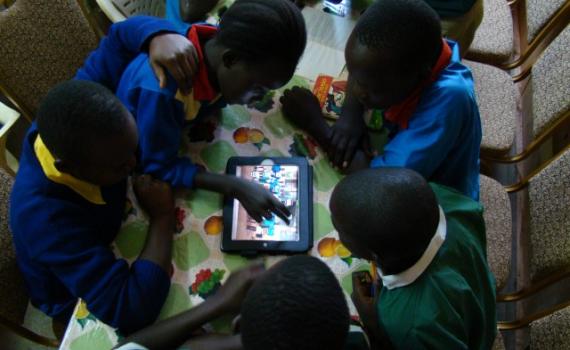 Children in Busia Community Library use tablet computers pre-loaded with educational content and educational games to help them with their school subjects. Children use tablet computers in the library.