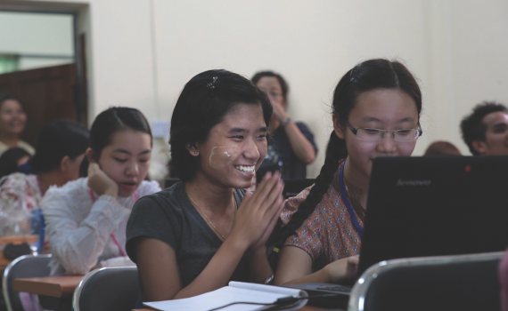 Students learn to use e-resources at the University of Yangon. Smiling students learning to use computers in University of Yangon.